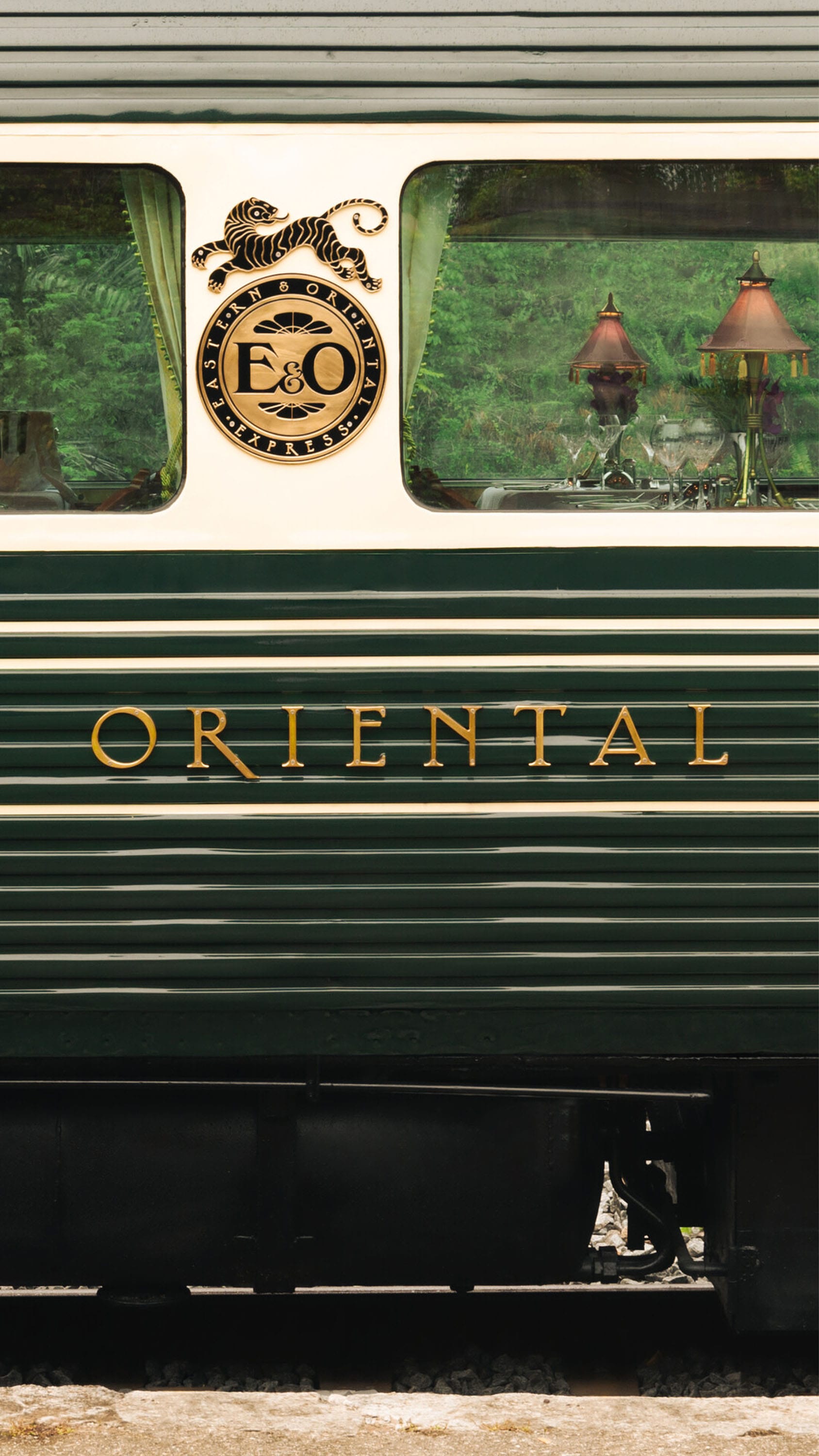 A photo of the outside view of the green and gold cars on the Eastern & Oriental Express train, which features a Dior Spa.